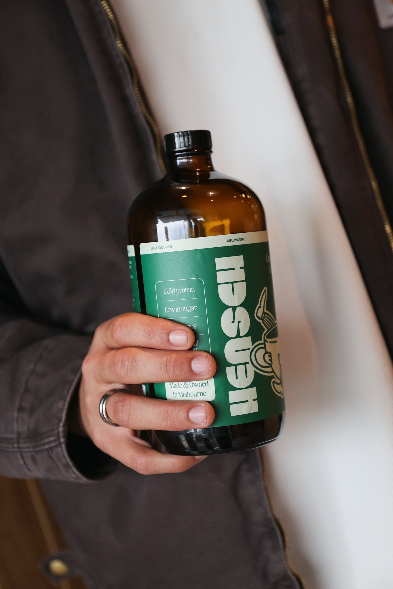 A hand holding a 480mL Hensch bottle