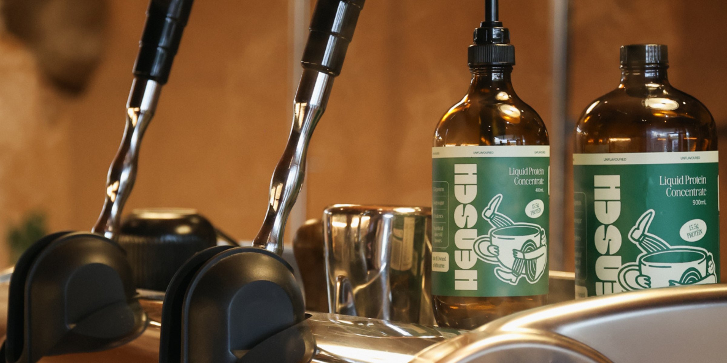 Two Hensch bottles on the back of an espresso machine