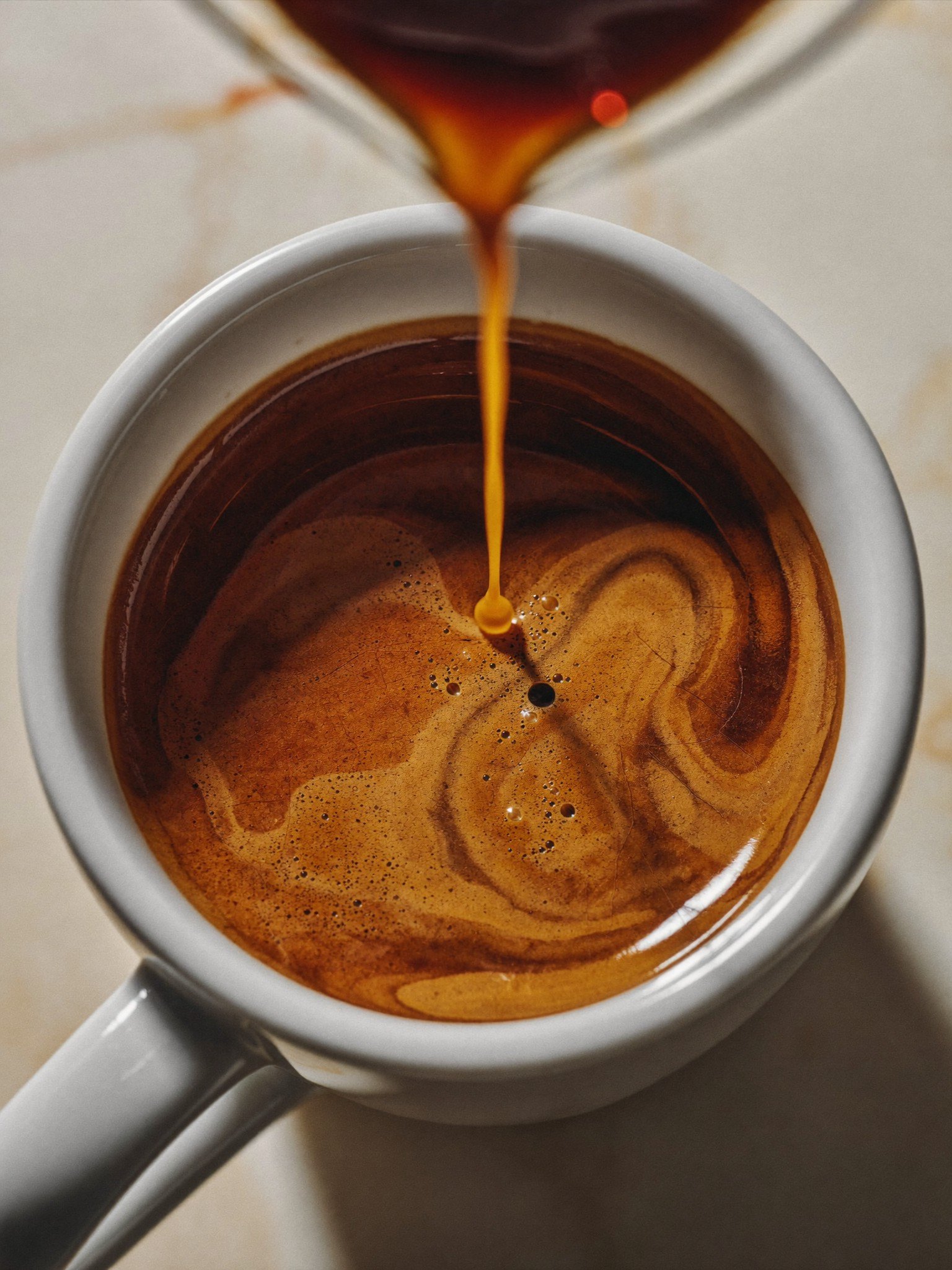 Espresso pouring into a white cup