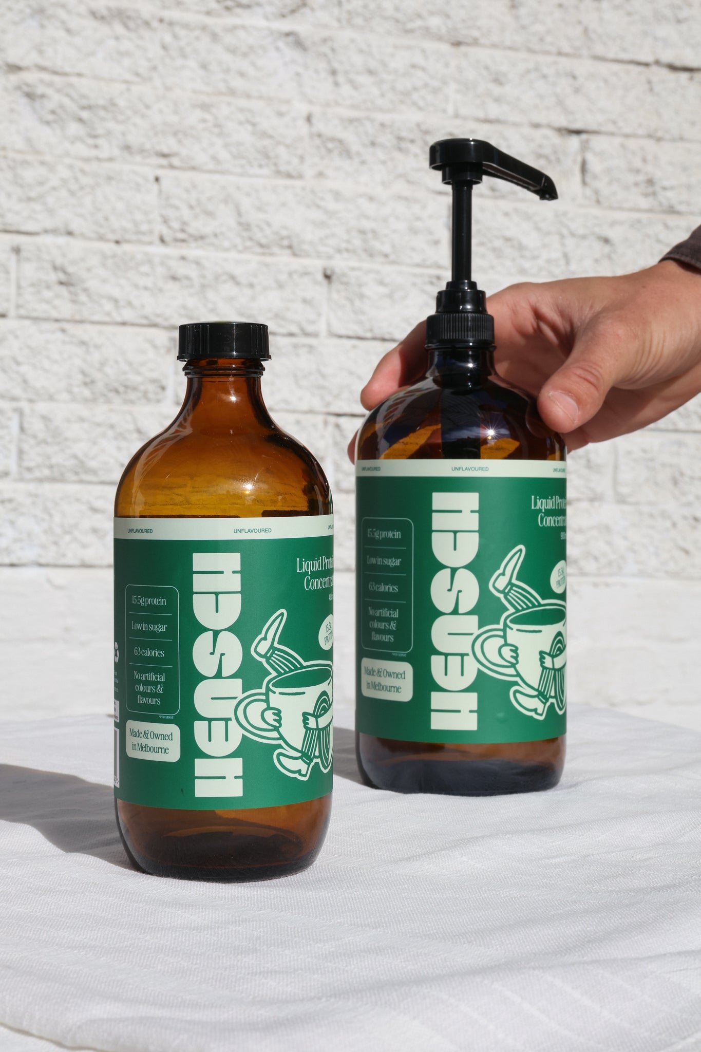 A hand pressing the Hensch pump on a bottle